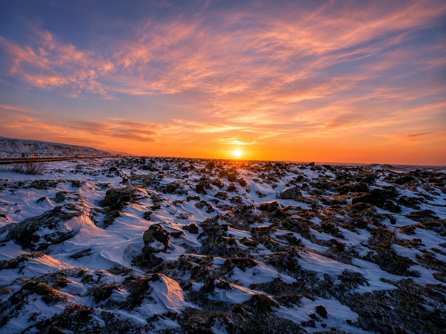 Snow dusted lava field at sunset
